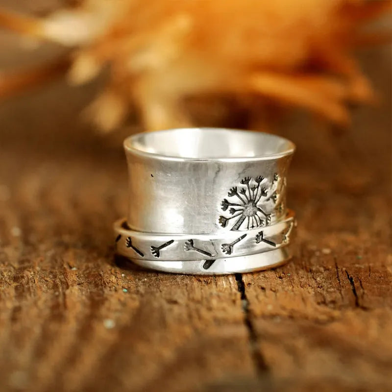 Silver colour rotatable flower ring on finger showing floral centrepiece