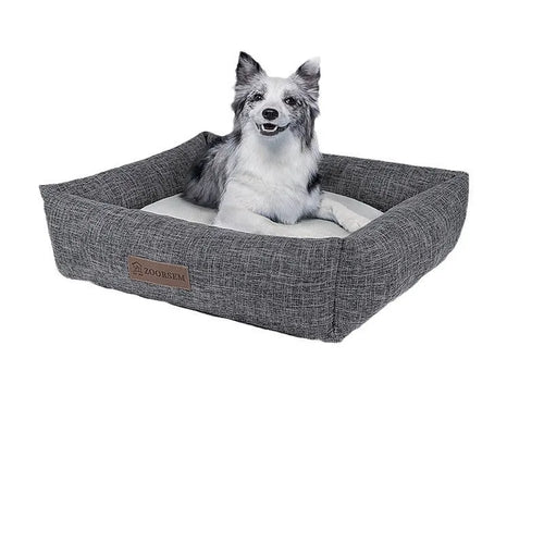 Grey plaid square cloth dog bed for medium-sized dogs on a wooden floor.