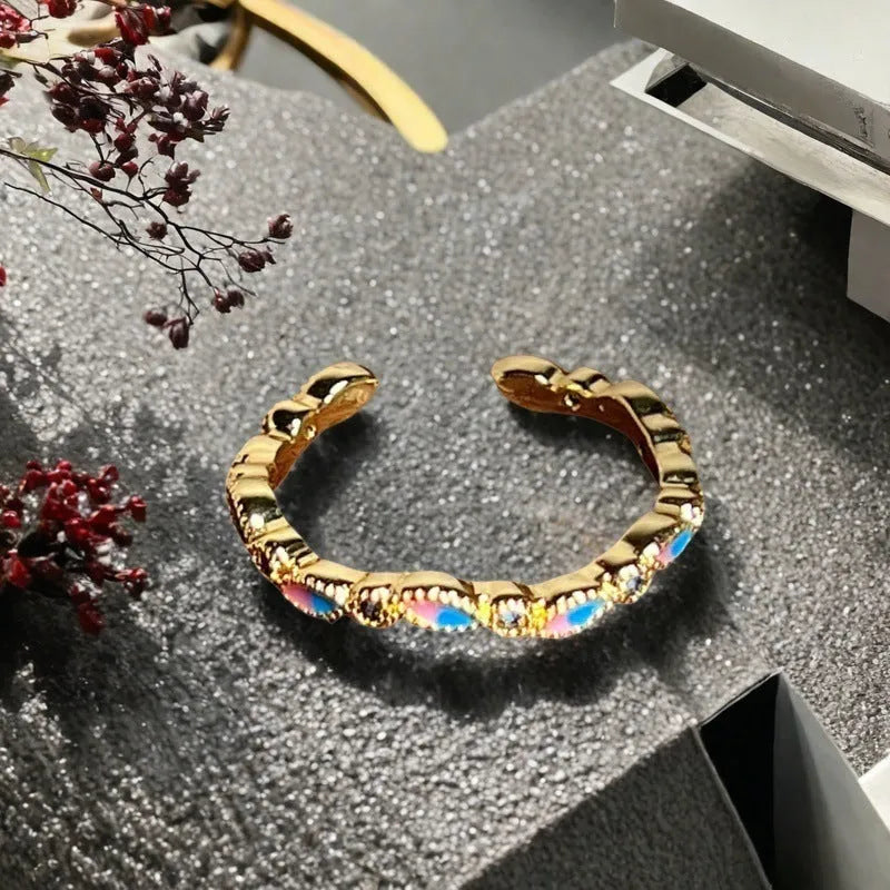 Adjustable Chinese gourd ring with zircon inlay showing floral and bow elements in oil-drip finish