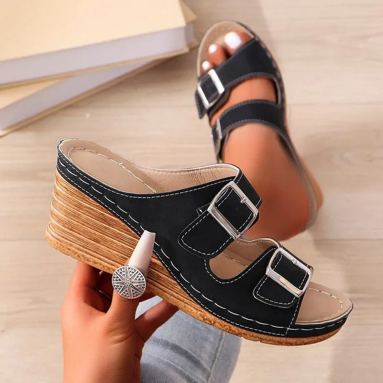 Women's creamy-white beach slippers with a decorative wedge buckle on the strap.