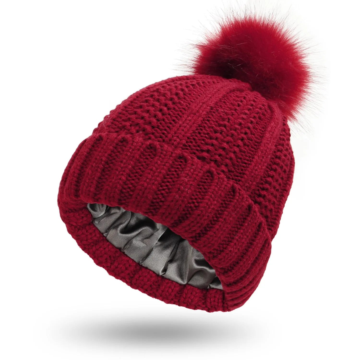 Women's black knit beanie with a faux fur pom pom and satin lining for hair protection