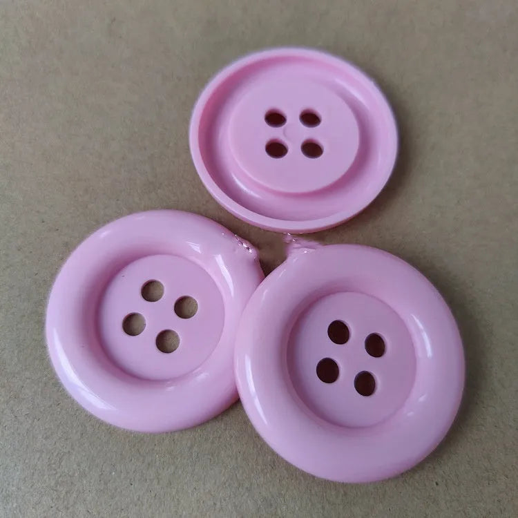 Oversized round plastic sewing buttons in multiple colours with four holes