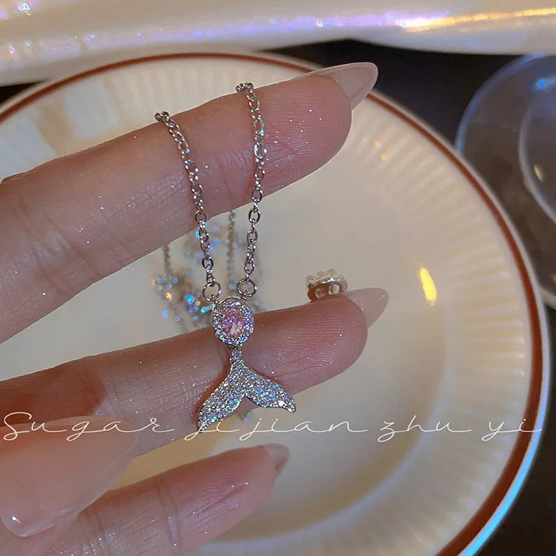 Close-up of a women's sterling silver geometric fishtail pendant necklace on an O-ring chain.