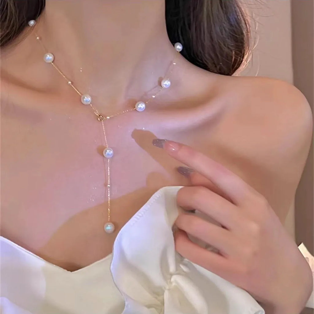 Gold starry pearl choker necklace on a white surface showing imitation pearl chain