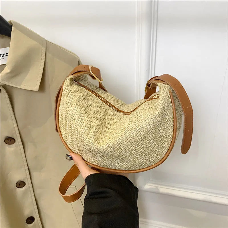 Women's straw woven crossbody bag showing woven texture and internal phone and document compartments