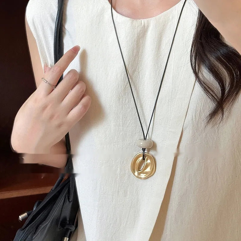 Geometric bow pendant necklace in gold alloy with artificial crystal accents on ladies long chain
