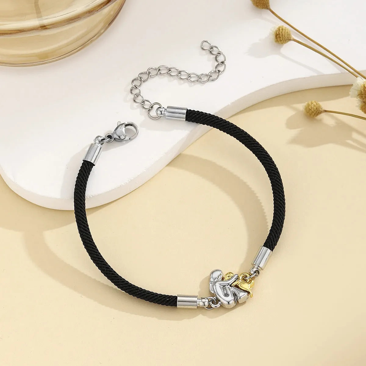 Woven angel motif couple bracelet in black with electroplated flexible wire finish