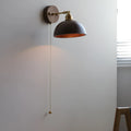 Nordic style walnut wood coloured wall-mounted bedside lamp with a fixed arm.