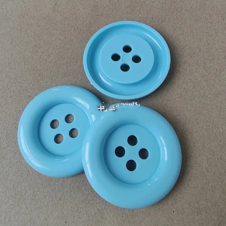 Oversized round plastic sewing buttons in multiple colours with four holes
