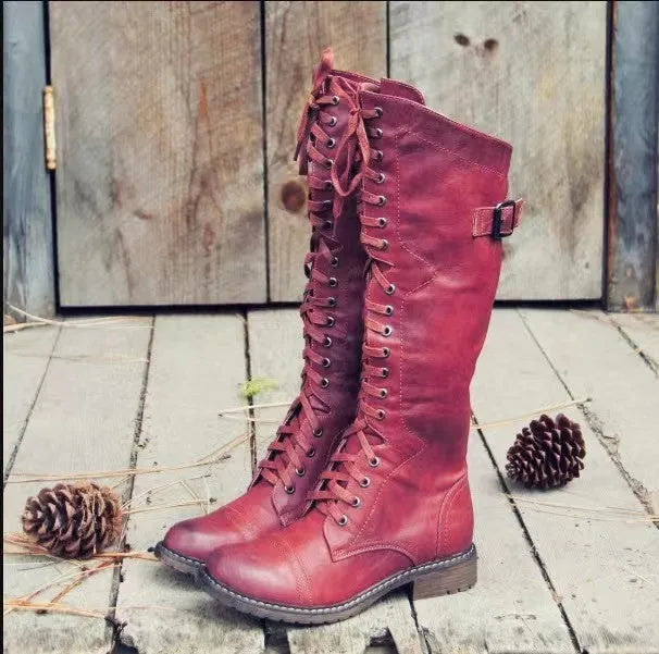 Women's black high leg boots with a chunky low heel and round toe on a plain background.