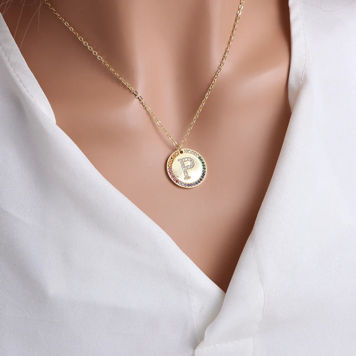 Gold round necklace with colourful crystal letter pendant on a clavicle chain