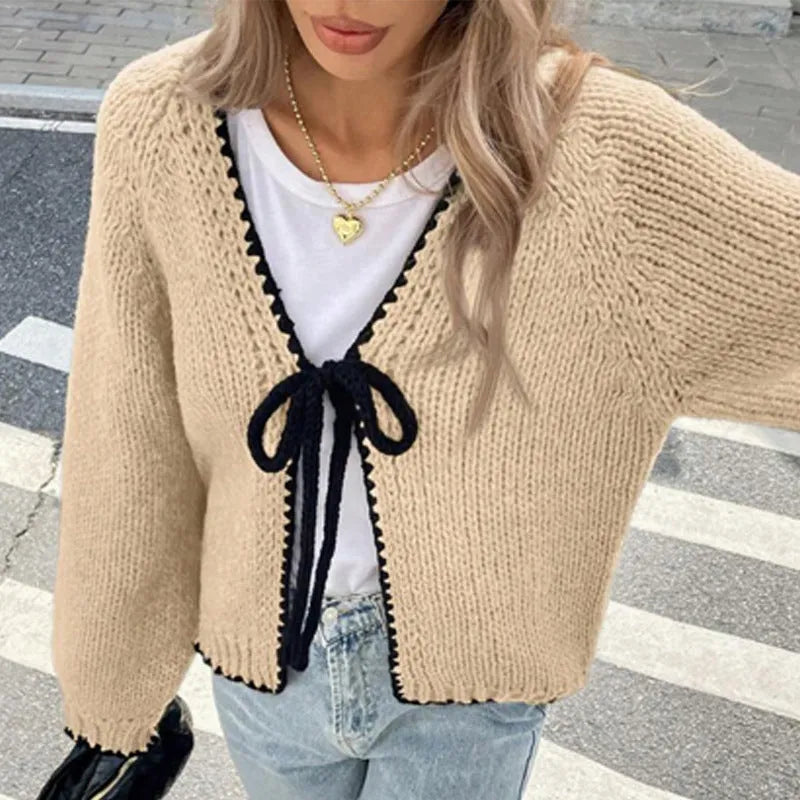 Gray lace-up cardigan sweater with long sleeves and crocheted flower decoration on the front.