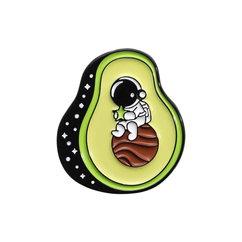 Colourful cartoon fruit design metal brooch with pin back on a fabric background.