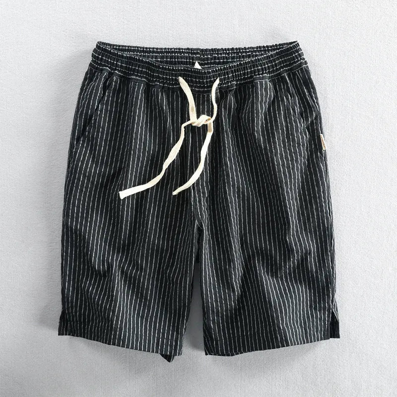 Man wearing black and white striped cotton casual shorts with a loose straight leg and elasticated waist.