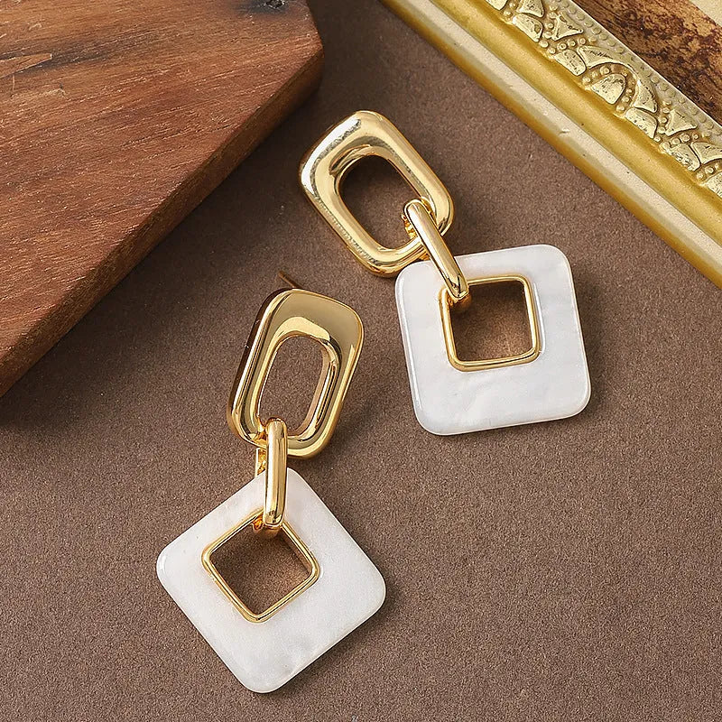 Pair of hollow geometric square earrings with chamfered pattern in silver or black electroplated finish.