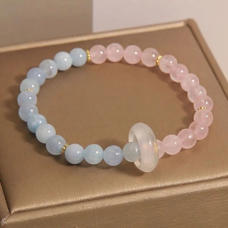 Aquamarine crystal bracelet with mixed materials including pink beads, white pearls, and peach blossom elements