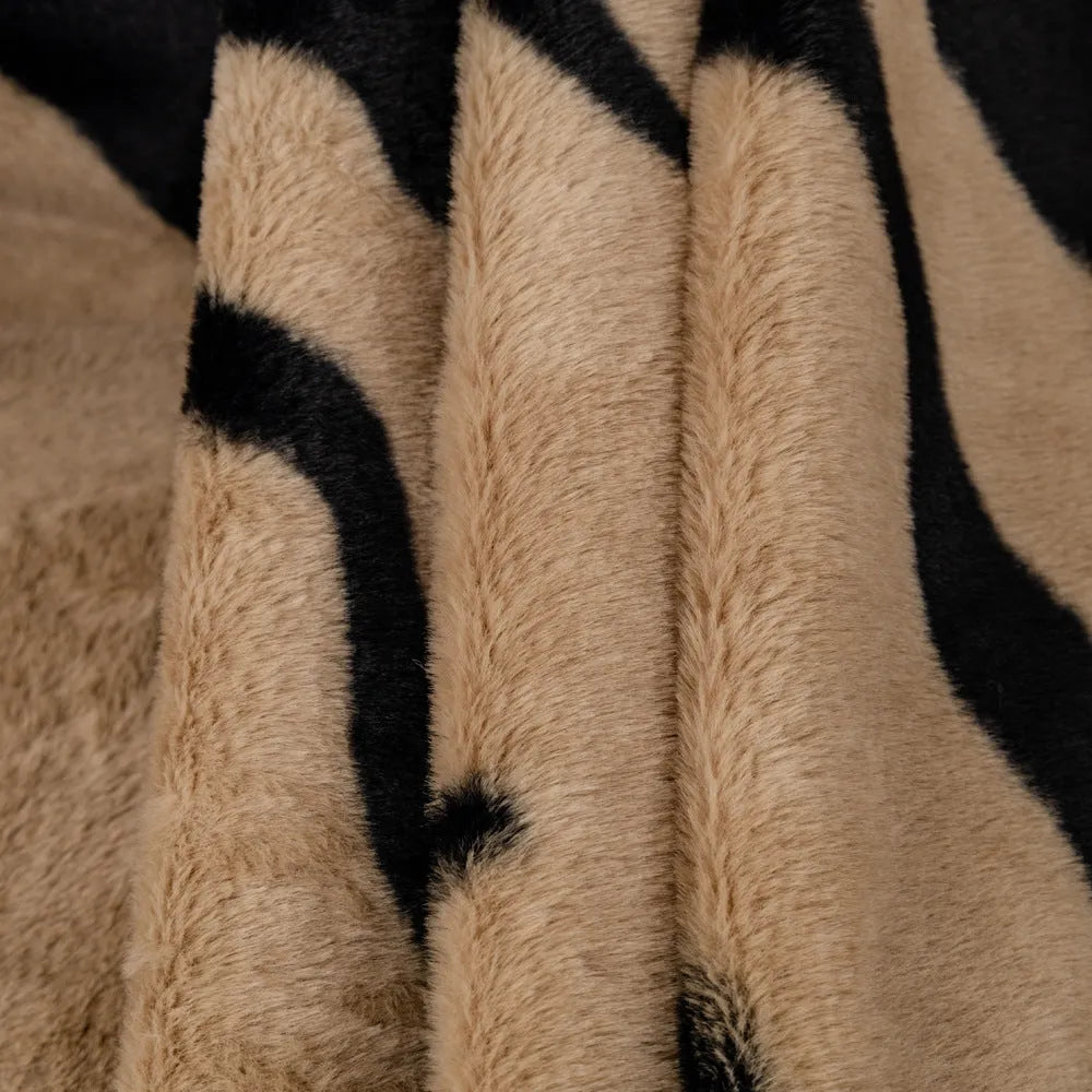Zebra pattern flannel sofa slipcover in caramel colour, shown draped over a sofa with matching square pillow.