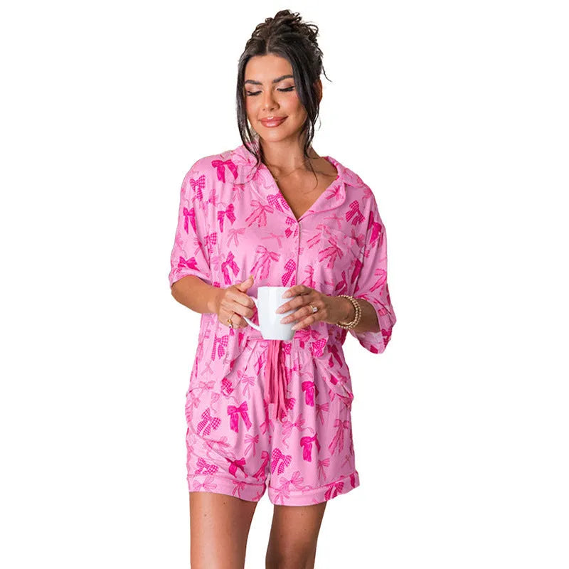 Pink bow print two-piece pajama set with a top and pants on a hanger