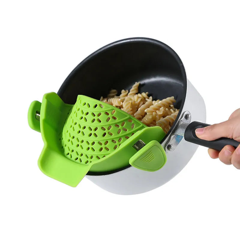 Silicone pot side drain stopper in black on a stainless steel pot edge, 11.3x22.5x5.9cm kitchen gadget