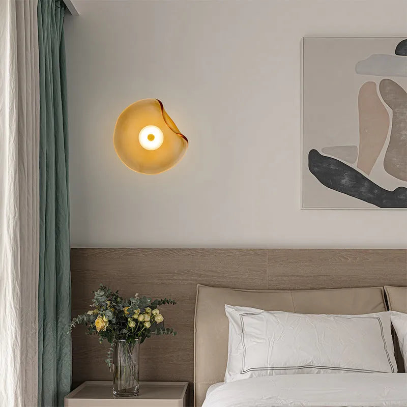 Round glass wall lamp in a choice of colours for bedroom bedside lighting.