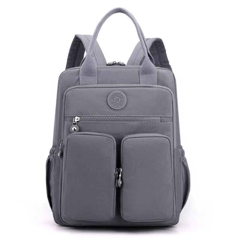 Waterproof women's large capacity nylon travel backpack in multiple colours showing internal laptop compartment and pockets.