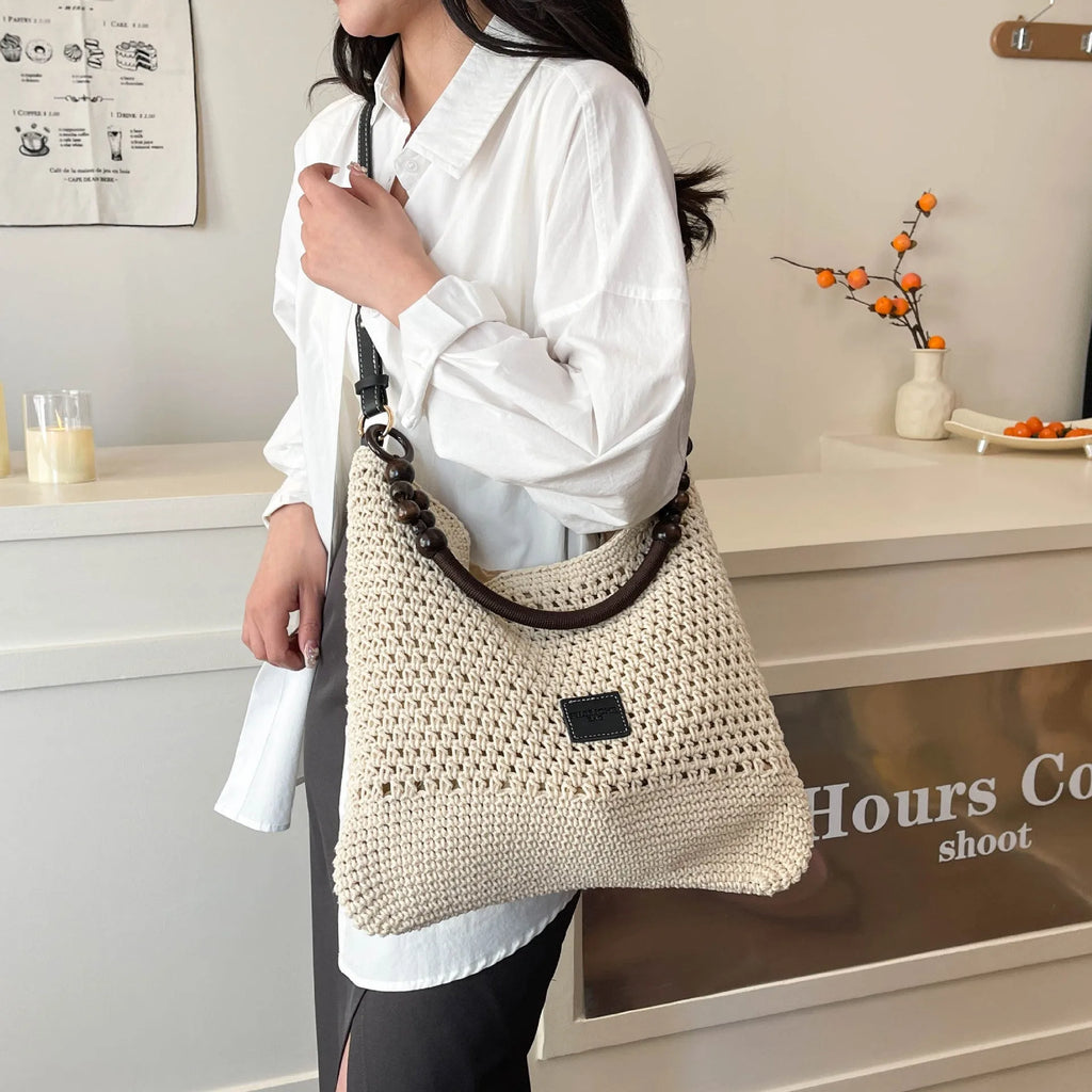 Knitted tote beach bag in bucket shape with crossbody strap showing contrast stitching details