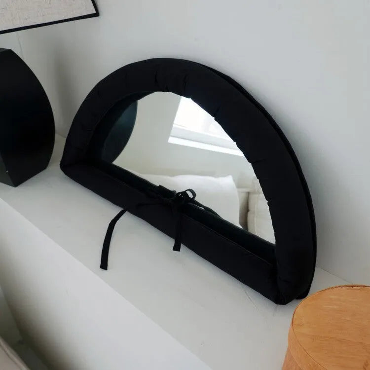 Rectangular white fabric mirror with soft filling hanging on a wall