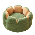 Green cactus petal shaped plush dog bed with a non-slip bottom on a wooden floor.