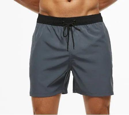 Men's blue fitness shorts with stitched waist headband, drawstring, zipper pocket, and padding for running