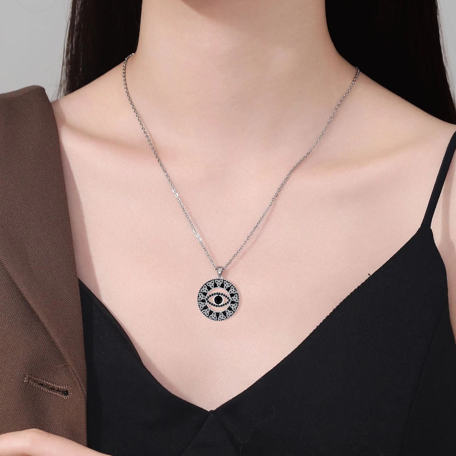 Copper Devil's Eye pendant necklace with cross chain design on display