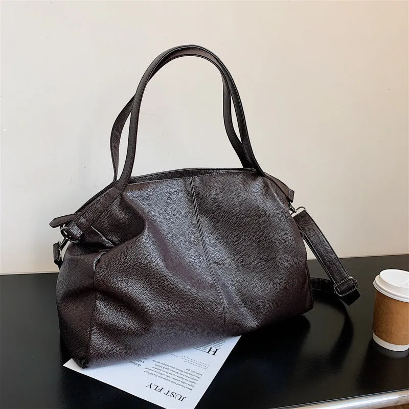 Large black PU leather messenger bag with shoulder strap showing internal organisation pockets