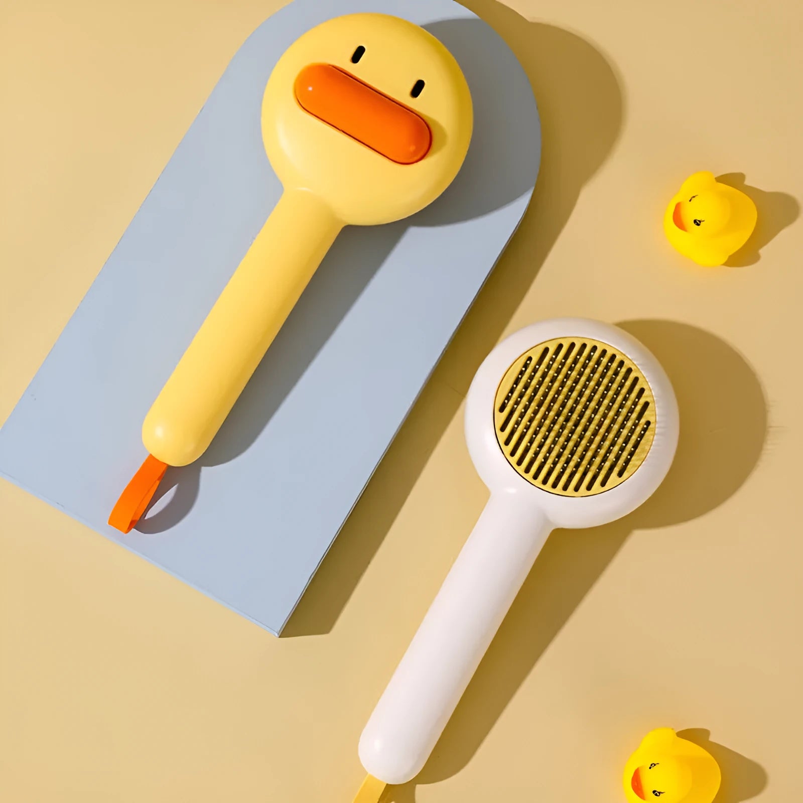 Small yellow duck-shaped pet comb with needle bristles for grooming cats and dogs