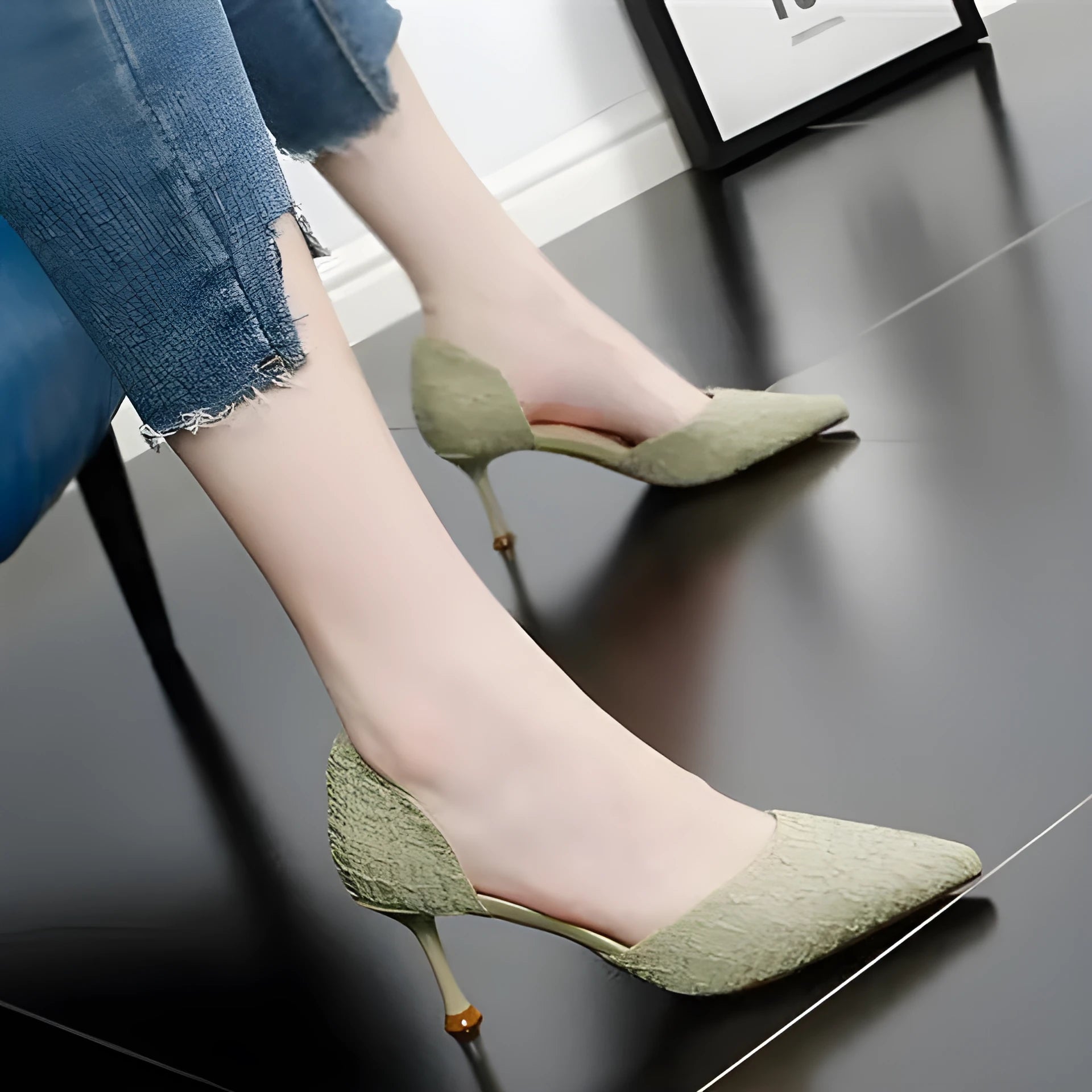 Women's black pointed leather high heel shoes with a stiletto heel on a plain background.