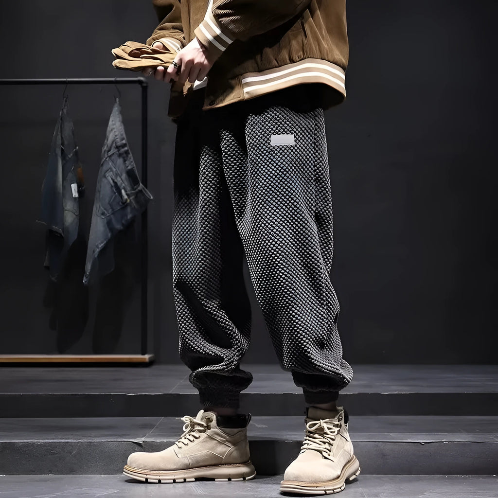 Men's grey straight-leg sweatpants with ankle ties on a plain background.