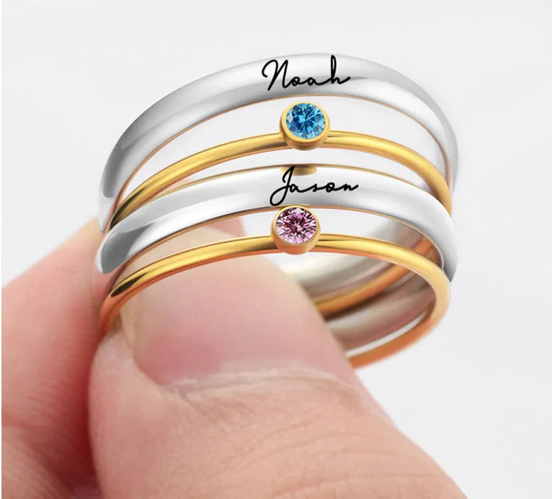 A geometric titanium steel ring featuring an engraved December birthstone design on a grey background.