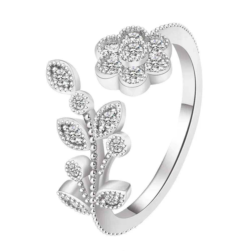Gold and white women's open ring with floral leaf design and diamond treatment.