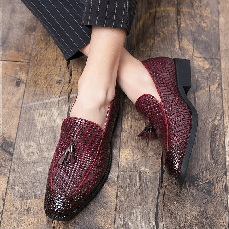 Men's black pointed slip-on business shoes with tassel detail on artificial PU upper.