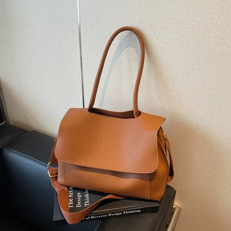 PU leather tote bag in beige with double shoulder strap and visible stitching detail.