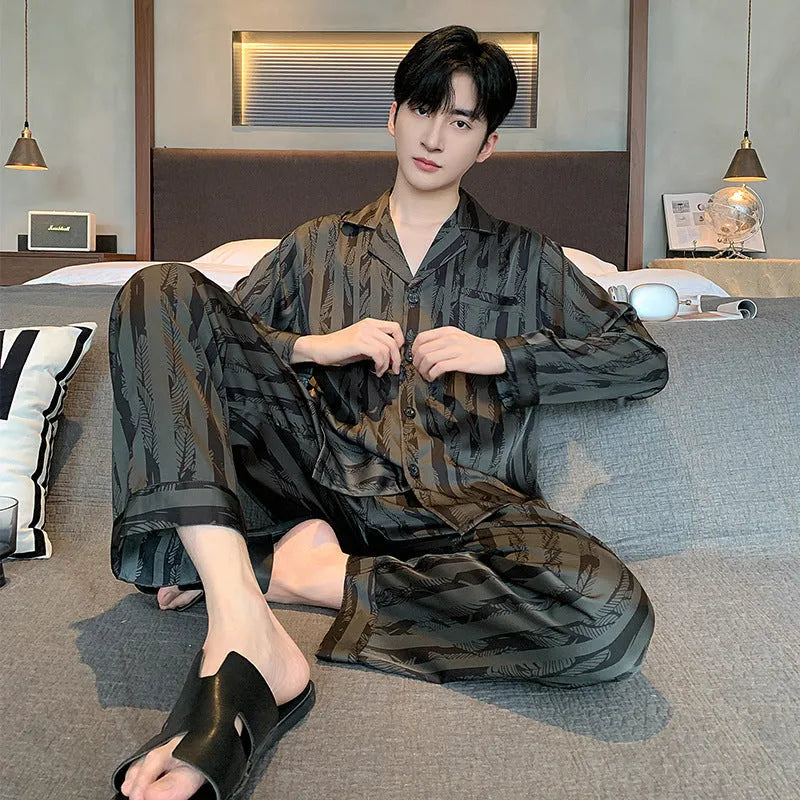 Men's black striped Ice Silk long sleeve V-neck pajama top and thin trousers set laid flat.