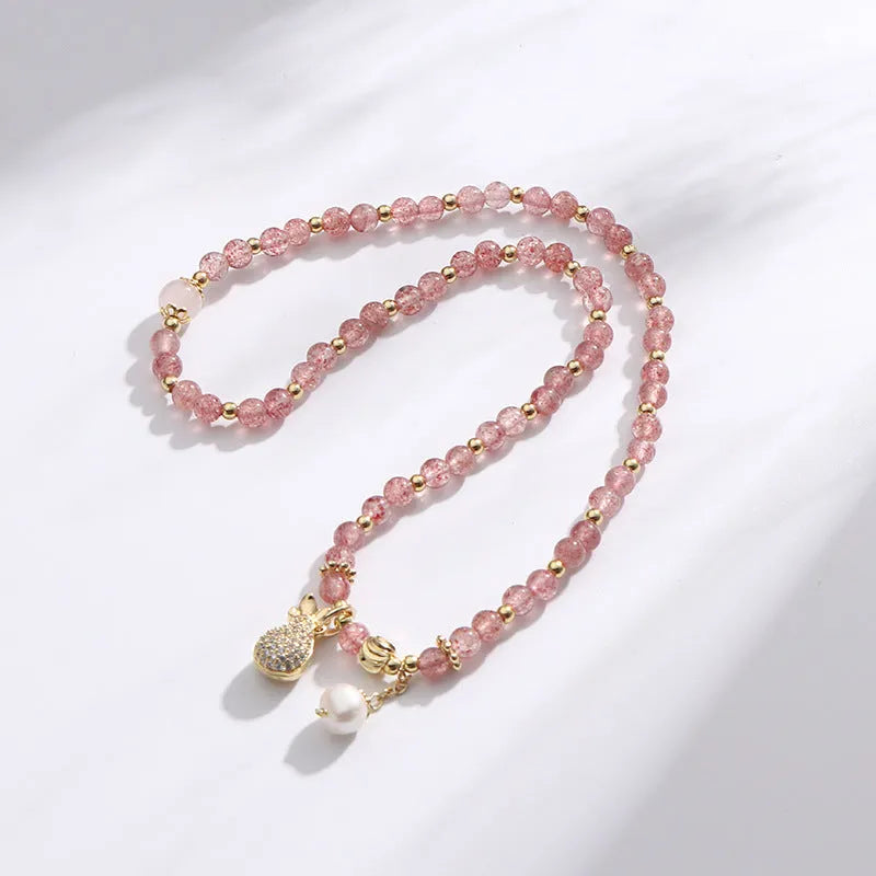 Women's strawberry quartz bracelet with geometric wallet-style design and adjustable beaded construction
