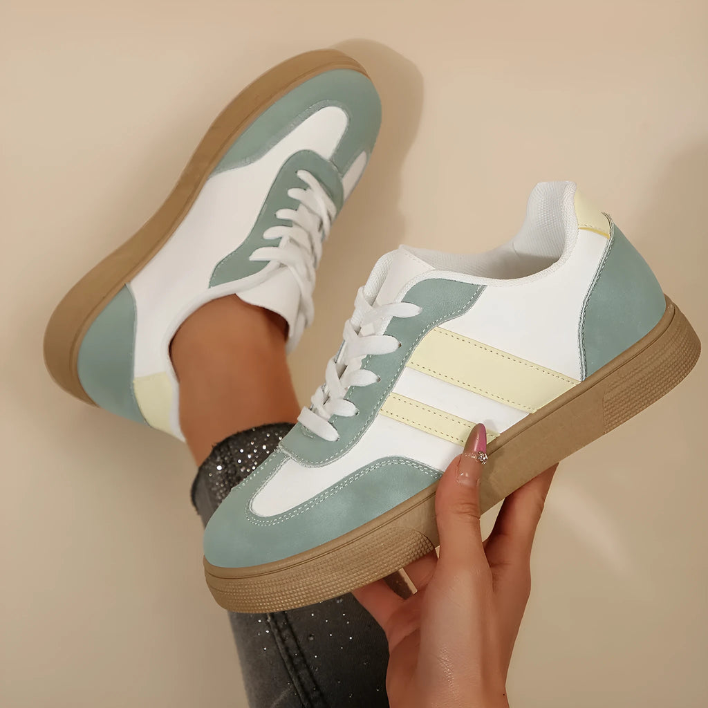 Green women's retro trainers with a cross strap design, round toe, and white rubber sole.