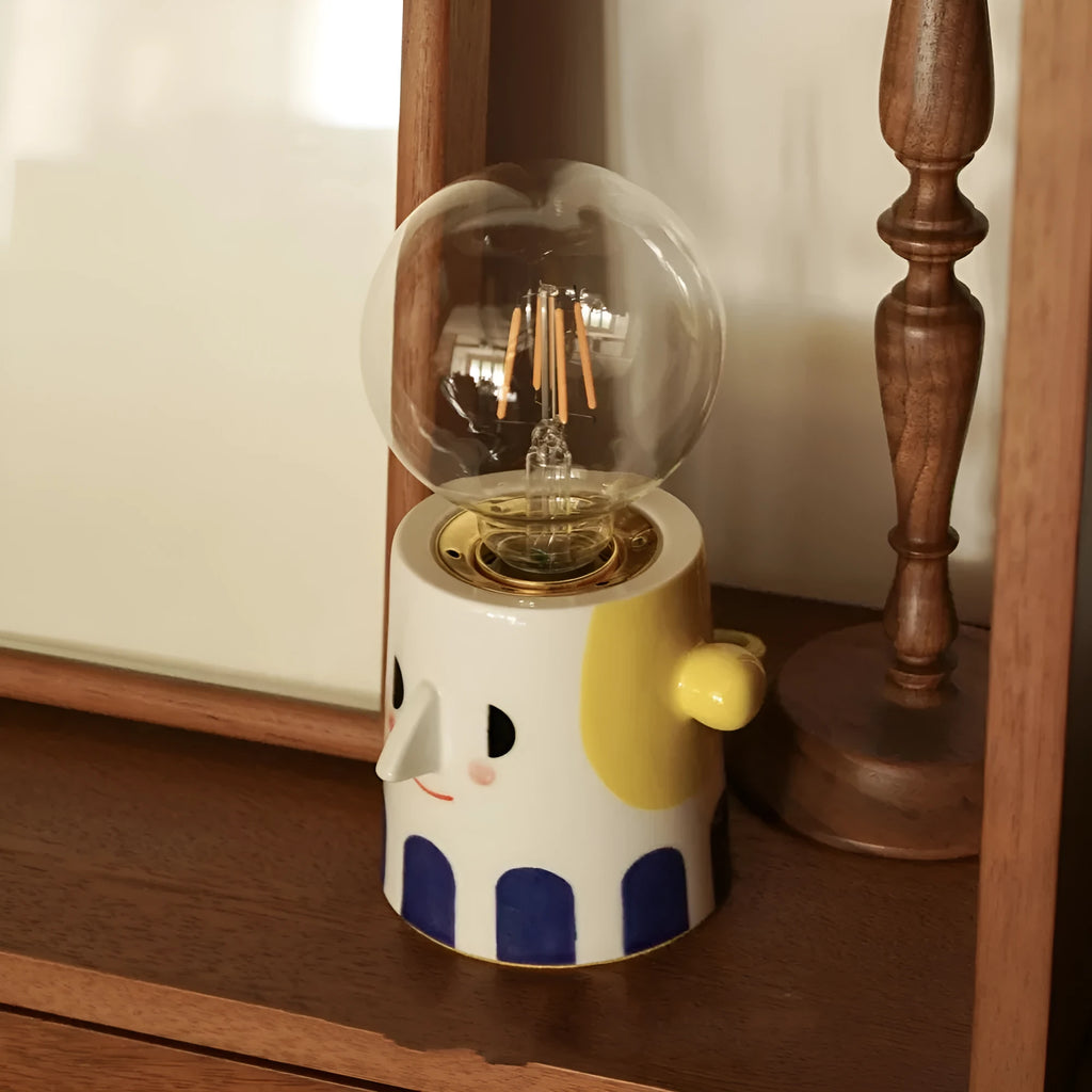 Handmade ceramic table lamp with ball headlight design on wooden surface