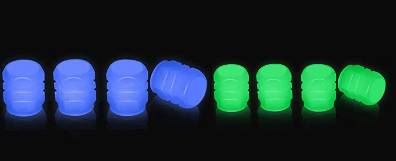 Pack of green and blue luminous rubber tyre valve caps on a car tyre valve.