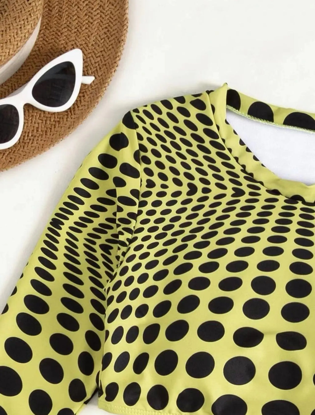 Women's green polka dot three-piece swimsuit set showing bra top and matching skirt
