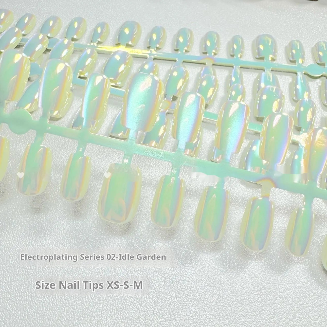 Set of electroplated Cat's Eye and aurora design false nails in short ladder XS, S, and M sizes.