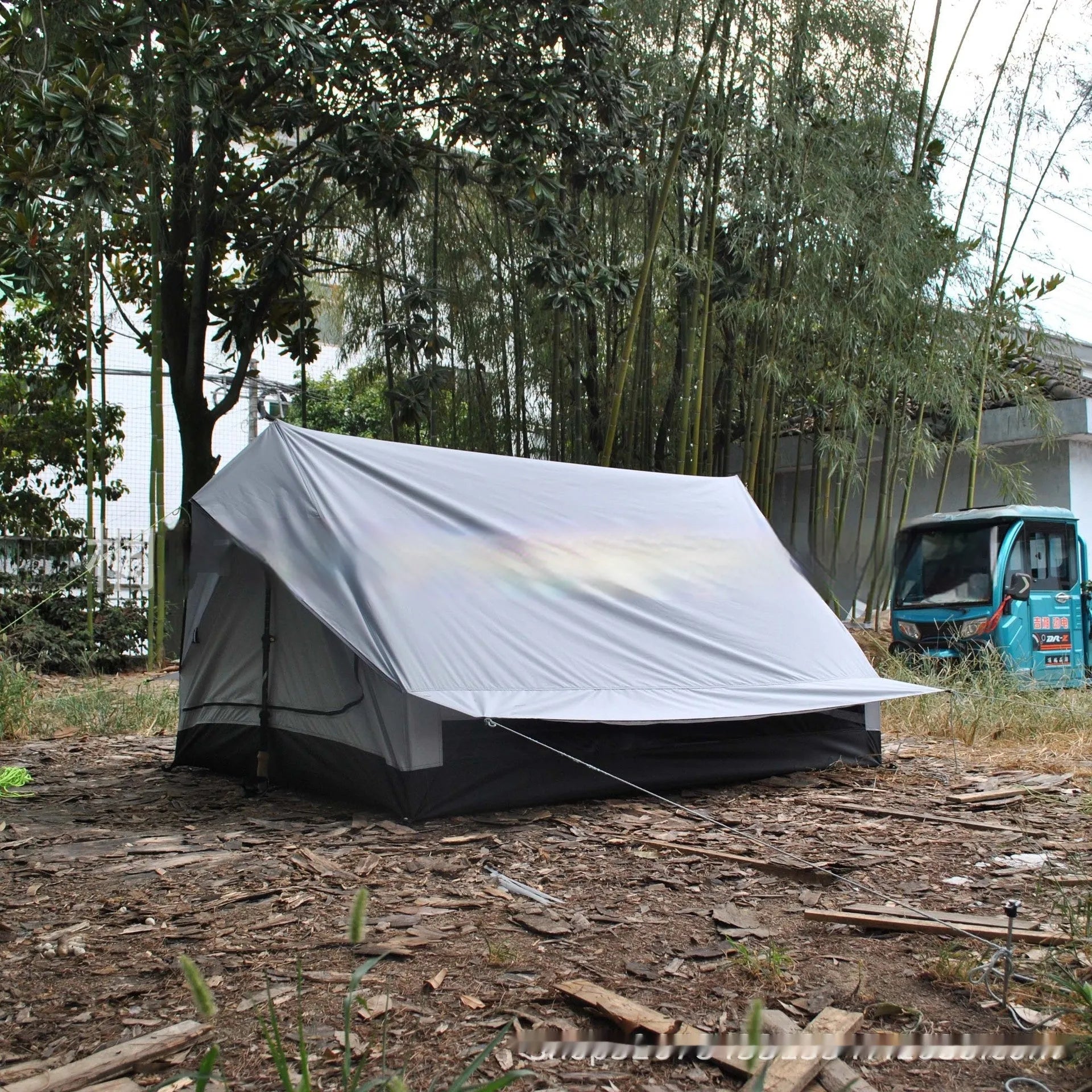 Brown A-line pole-free portable tent with hiking cane support showing interior space for 2-3 people