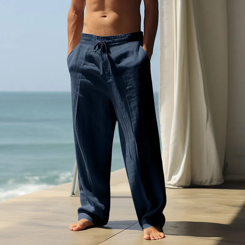 Men's loose-fit cotton casual trousers in a solid colour on a hanger.