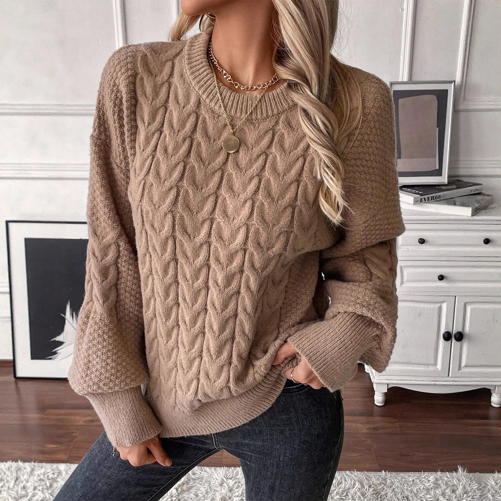 Woman wearing a loose beige casual sweater with a twisted texture detail on the front.