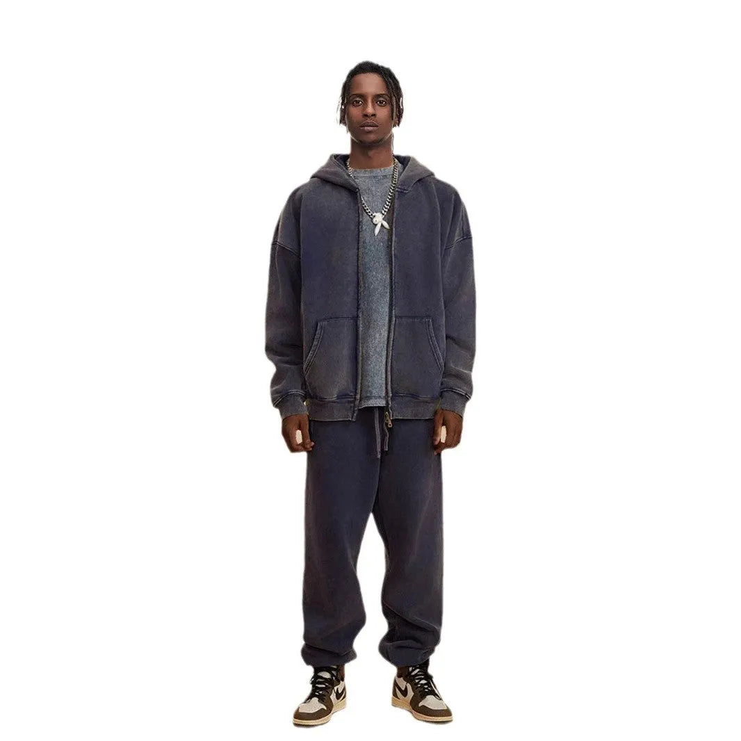 Man wearing a washed black fleece-lined hooded cardigan sweater with a double zip.
