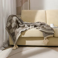 Acrylic sofa blanket with tassels in geometric pattern colour option on a sofa